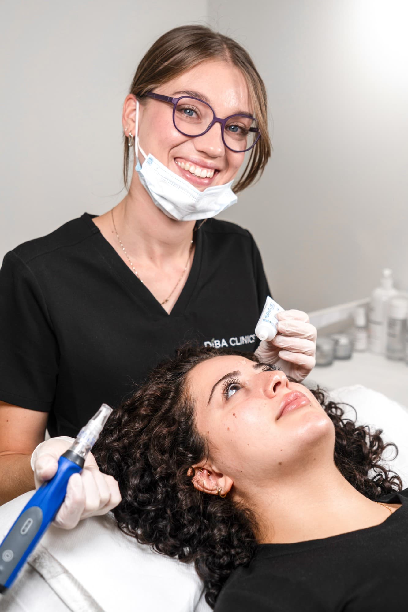 Een behandelaar van Diba Clinics met de microneedling-pen, de klant ligt klaar in de stoel